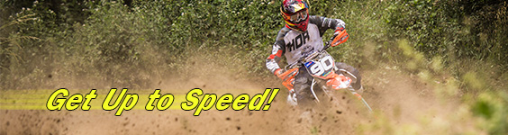 A person wearing a crash helmet rides a dirt bike very fast while thick clouds of dirt and dust follow in their wake. To the left of them is text which reads get up to speed.