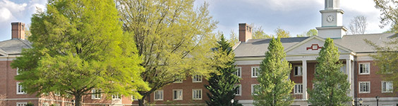 An image of part of Radford University in Radford, Virginia showing brick colonial style buildings with leafy trees in front.