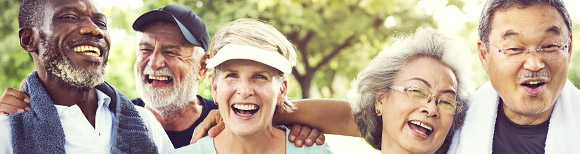 Decorative. Five adults near retirement age wearing weekend attire smile and laugh while enjoying one another