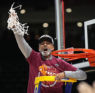 Coach Kenny Brooks taking down the nets after winning the championship