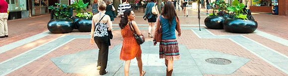 Rear view of three women walking through Downtown Mall in Charlottesville, Virginia.
