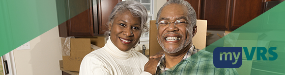A retired couple smiling at the viewer in the kitchen of their new retirement home. Moving boxes are on the countertop in the background. On the right is the my VRS logo.
